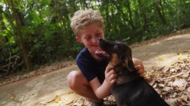 Tayland 'da gündüz vakti elinde köpek yavrusu tutan bir çocuğun videosu.