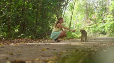 Tayland 'da gündüz vakti ormanda köpek besleyen genç bir kız.