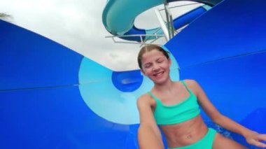 Bir kız elinde kamerayla Tayland 'da bir su parkında kaymaktan ve su sıçratmaktan zevk alırken kendini filme çekiyor.