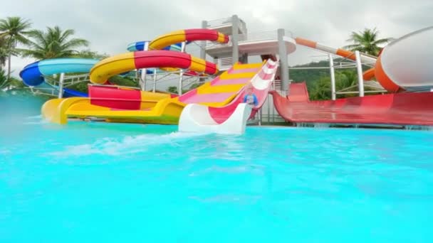 Wide Shot Colorful Water Slides Boy Wearing Rashguard Sliding One — Stock Video