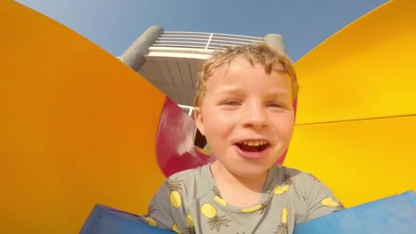 Niño Joven Con Guardabarros Flotadores Brazos Sonriendo Mientras Desliza Tobogán — Vídeos de Stock