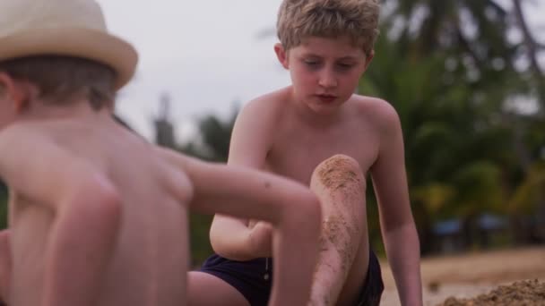 泰国一个男孩白天在沙滩上挖沙子的视频 — 图库视频影像