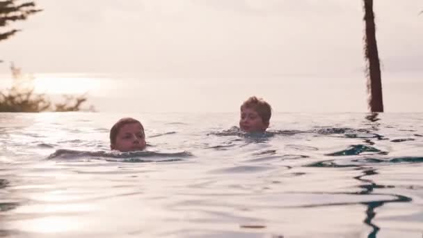 Video Zachycující Chlapce Dívku Plavající Nekonečném Bazénu Během Západu Slunce — Stock video