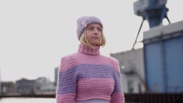 カメラはピンクと紫のウールのセーターの女性に焦点を当ててズームします — ストック動画