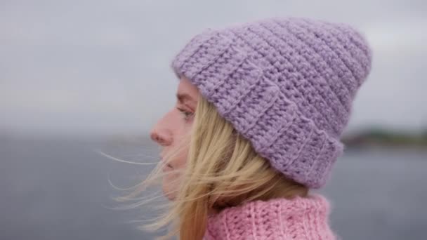 一个特写的弧形镜头拍摄到一个穿着温暖羊毛毛衣和针织帽子的女人凝视着地平线 — 图库视频影像