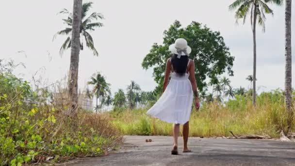 Camera Follows Young Woman She Strolls Road Lined Grass Coconut — Stock Video