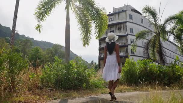 Woman White Dress Hat Walks Slowly Grassy Road Lined Coconut — Stock Video