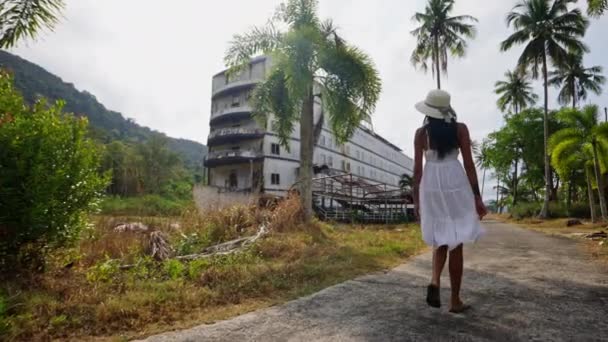 Woman Strolls Path Lined Grass Trees Observing Scenery Nearby Abandoned — Stock Video