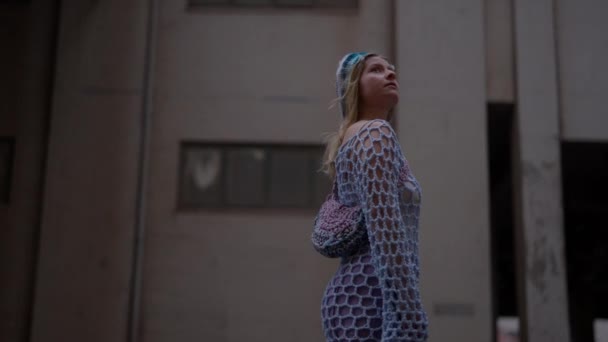 Açık Mavi Örgü Elbiseli Sarışın Bir Kadının Gündüz Binaların Yanında — Stok video