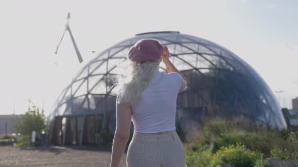 Egy Fehér Inges Szőke Visszapillantó Képe Amint Megérinti Rózsaszín Sapkáját — Stock videók
