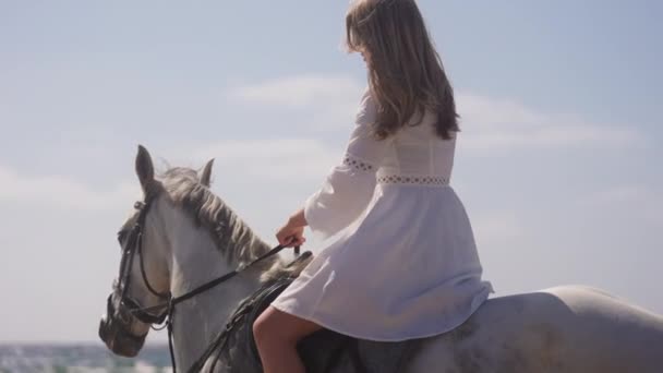 Średni Pełny Strzał Dziewczyny Białej Sukience Jeżdżącej Białym Koniu Plaży — Wideo stockowe
