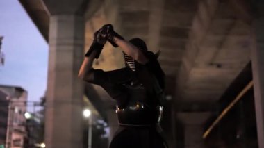 Kendo kıyafetli adam kılıcının hızlı bir kavisi ile büyüleyici bir kontrol gücü sergiliyor.