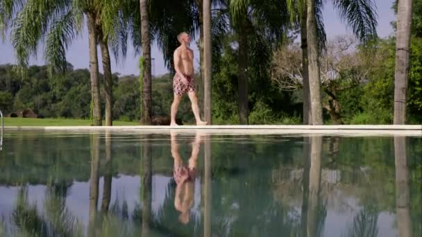 Walks Poolside Resort Broad Daylight Mans Reflection Seen Water Pool — Stock Video