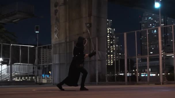 Şehir Manzarasının Ortasında Adam Gece Kendo Antrenmanına Gider — Stok video