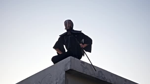 Auf Einem Hoch Aufragenden Gebäude Sitzt Ein Mann Seinem Kendo — Stockvideo