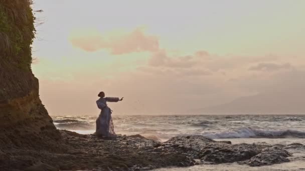 Een Vrouw Een Jurk Dansend Gracieus Aan Rotsachtige Kust Met — Stockvideo