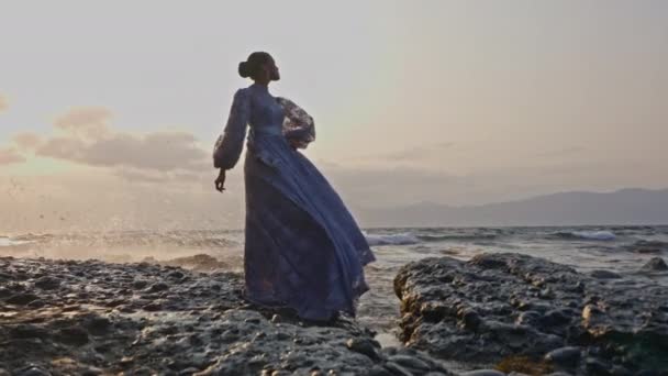 Kobieta Koronkowej Sukience Spokojnie Stojąca Skalistym Wybrzeżu Falami Rozbryzgu Podczas — Wideo stockowe