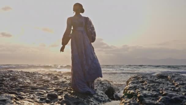 Kobieta Koronkowej Sukience Stojąca Rozglądająca Się Skalistym Wybrzeżu Falami Rozbryzganymi — Wideo stockowe