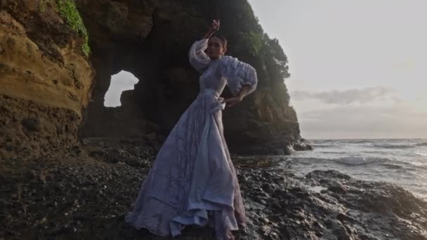 Kobieta Radośnie Tańczy Przeciwko Rozbryzganym Falom Morza Podczas Zachodu Słońca — Wideo stockowe