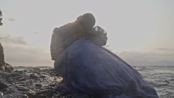 一个女人平静地沿着崎岖的海岸线坐着 — 图库视频影像