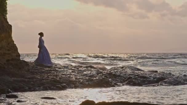 Широкий Снимок Женщины Кружевном Платье Идущей Скалистом Берегу Морскими Волнами — стоковое видео