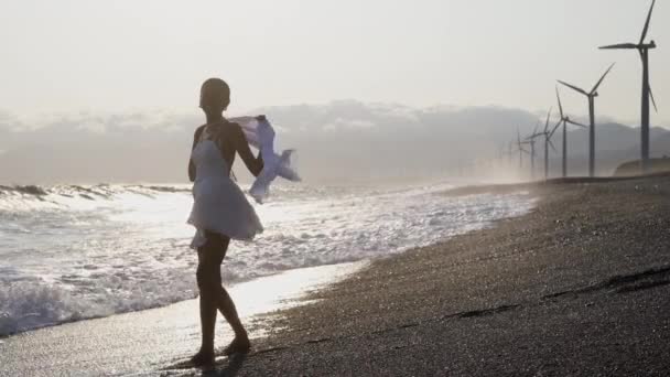 海浪冲击着海岸 把一个穿着流线型衣服的女人溅了出来 — 图库视频影像