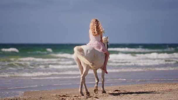Wide Back View Shot Blonde Girl Riding Unicorn Beach Oncoming — Stock video