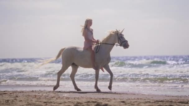 Широкий Знімок Блондинки Сукні Їзда Білому Єдиноріг Пляжі Зустрічними Хвилями — стокове відео