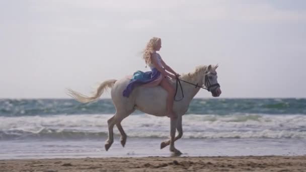 Широкий Знімок Блондинки Синьо Фіолетовій Спідниці Їзда Білому Єдиноріг Пляжі — стокове відео