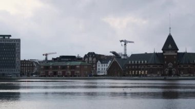 Aarhus Nehri 'nin Danimarka' nın Aarhus şehrinde uzanan ve arka planda uzun vinçler bulunan manzarası.