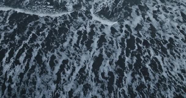 ベストラホーンの黒い砂浜は オーバーヘッドショットで白い海の波と対照します — ストック動画