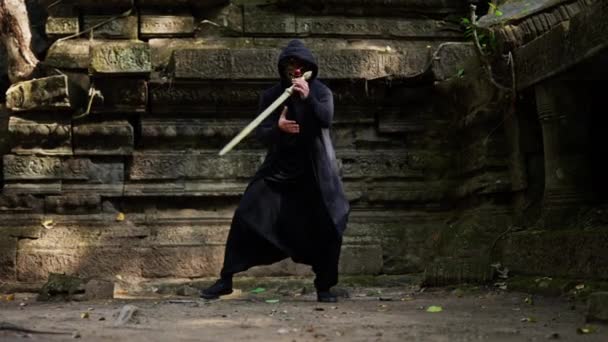 Zoom Tiro Homem Capa Malabarismo Sua Espada Dourada Templo Abandonado — Vídeo de Stock