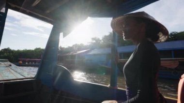 Tekne gezisi sırasında bir kadının üzerinde parlayan güneş ışınları.