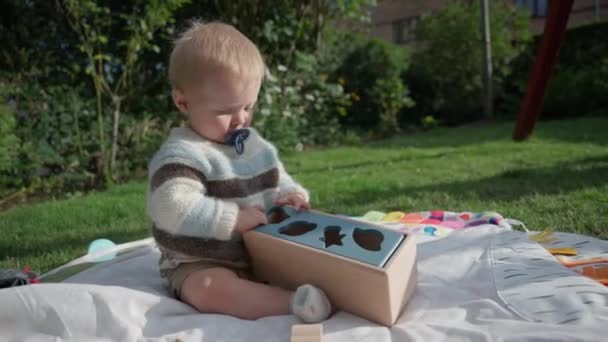 Bebê Mordendo Suavemente Uma Chupeta Enquanto Joga — Vídeo de Stock