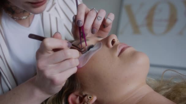 一个女人的睫毛是由一个熟练的美容师用金属镊子用特写完成的 — 图库视频影像
