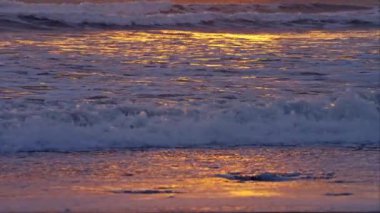 Deniz dalgaları zarif bir şekilde sahile vuruyor büyüleyici bir dansla.