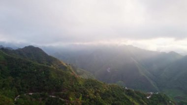 Hava manzarası, dalgalanan zirveleri ve vadileriyle karakterize edilen geniş dağlık bir bölgeyi ortaya çıkararak büyüleyici bir doğal mozaik yaratıyor..
