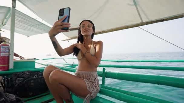 一个女人一边享受坐船的乐趣 一边一边高兴地微笑着 同时又抓着一个自拍 以珍藏那段美妙的经历 — 图库视频影像