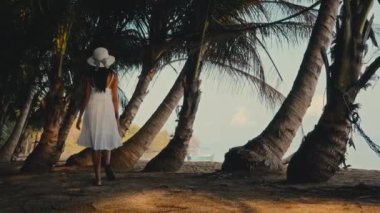 Gündüz vakti Koh Mak 'ın palmiyeleri arasında gezen bir kadın.