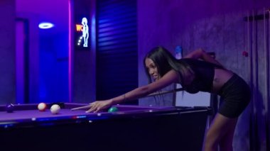 Yetenekli bir kadın inceliğini ve yeteneğini sergilerken aynı zamanda ustalıkla ve stiliyle bilardo oynuyor.