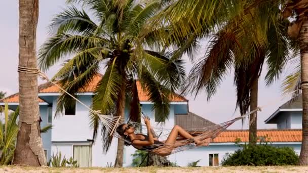 Woman Swaying Gently Hammock Engrossed Her Phone Palm Trees Villas — Stock Video