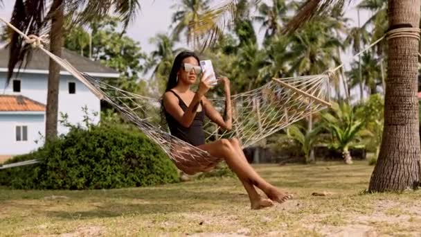 Woman Chic Black Swimsuit Lounges Hammock Taking Perfect Selfie Treasure — Stock Video