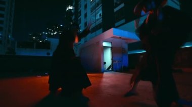 Bir erkek ve bir kadın etkileyici Kung Fu yeteneklerini şehir binalarına karşı güç, hassasiyet ve zarafet harmanlayarak gösteriyorlar.