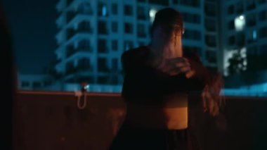 Gece karanlığında, usta bir Kung Fu ustası çatıda duruyor.