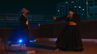 Gece karanlığında, Kung Fu savaşçıları çatıda antrenman yapıyor.