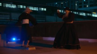 Bireyler gece vakti Kung Fu hünerlerini ustalıkla çatıda geliştiriyorlar.