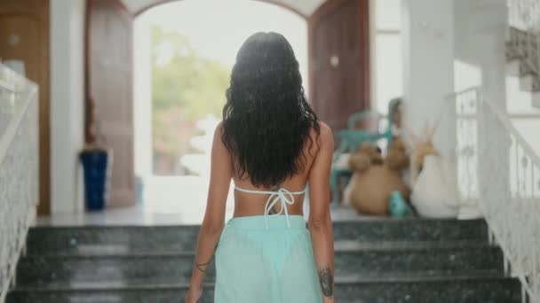 アクアマリンビキニを着た女性のバックビューショットは 豪華なヴィラで階段を上り 沿岸の退却のケアフリーな精神を体現します — ストック動画