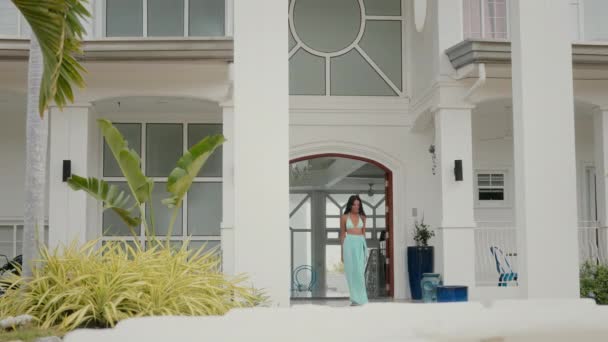 一个女人优雅地走出了一座现代别墅 阳光的温柔拥抱照亮了她 — 图库视频影像