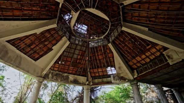 剥皮的油漆 暴露的结构框架和风吹日晒的木头揭示了一个曾经优雅的凉亭屋顶上时间的流逝 — 图库视频影像