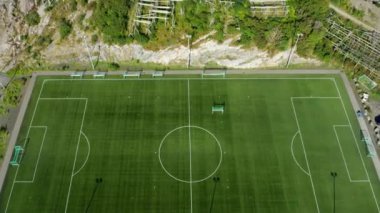 Yukarıdan boş bir futbol sahası, gündüz boyunca açık alanın dingin sessizliğini yakalıyor.